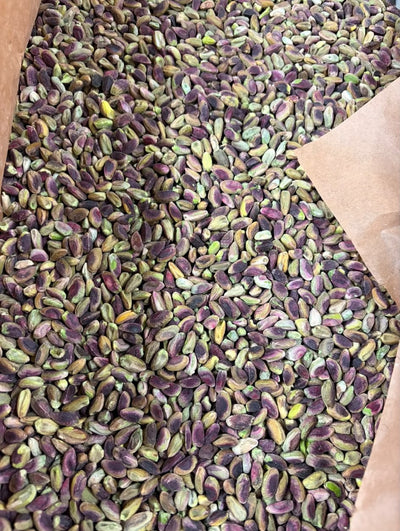 Raw Afghan pistachio kernels (pista giri) with natural purple and green skins, in a paper sack — Ghafori Foods