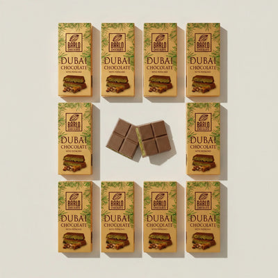 Box of 10 Barlo Dubai Chocolate with Pistachio 100g bars laid out, with two squares showing the pistachio filling — Ghafori Foods